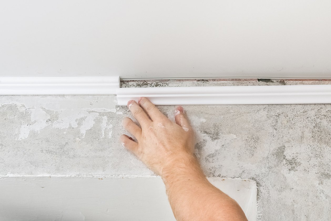 Worker Fixes the Plastic Molding to Ceiling. 